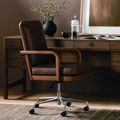 an office chair sitting in front of a desk with a vase on top of it