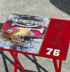 a table with a football helmet on it and the name of the game is painted on it