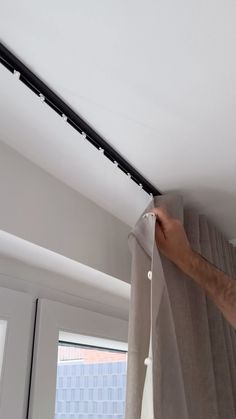 a person is pulling curtains off the ceiling