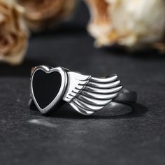 Jeulia "Winged Heart" sterling silver ring,a black heart ring, with rings in the side of solitaire.Wings symbolize freedom, strength, protection, spiritual sublimation, and rebirth. They stimulate our desire for self transcendence and encourage us to pursue better and more noble things. Give me the rest of your life, let me protect you. A simple oath, a promise for a lifetimeWeight: 3.76 gWidth: 2.2 mmHeight: 2.6 mmThickness: 1.1 mmMaterial: Plating Color: Silver Black Stainless Steel Promise Ring, Black Stainless Steel Jewelry For Memorial, Black Stainless Steel Promise Jewelry, Spiritual Black Jewelry For Promise, Black Symbolic Jewelry For Promise, Black Heart-shaped Promise Jewelry, Black Promise Ring For Valentine's Day, Symbolic Black Stainless Steel Rings, Black Symbolic Jewelry For Anniversary