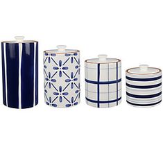 four blue and white canisters are lined up in the same pattern as each other