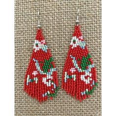 red and green beaded christmas tree earrings on a brown cloth with white trimmings