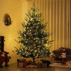 a christmas tree is lit up in the living room with presents on the floor next to it