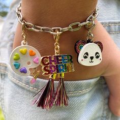 a close up of a person wearing a bracelet with charms