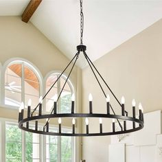 a large chandelier hanging from the ceiling in a dining room with arched windows