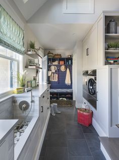 a narrow kitchen with tile flooring and white cabinets, along with open shelving