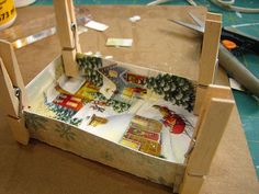 a small wooden box with christmas decorations on it and some scissors next to the boxes