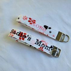 two lanyards with dog paw prints and the words babe's mom on them