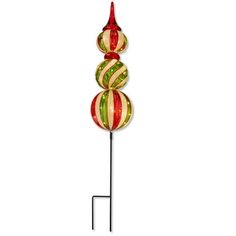 a red, green and yellow striped glass ball on a metal stand with a white background