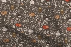 an animal print fabric with various animals and flowers on grey background, close up view