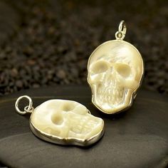 Hand carved Mother of Pearl skull necklace with sterling silver frame, This delicate charm is beautifully detailed. An edgy unique gift to a special someone. Comes on a 16 inch chain Material: 925 Sterling silver Mother of Pearl Dimensions : H: 20mm All of our jewellery packed in our labeled gift box Let us know if you have any questions, we would love to help you. For more of our necklaces please click here: https://www.etsy.com/uk/shop/Tribulondon?sort_order=date_desc&section_id=16135914 H Pearl Skull, Fake Gauge Earrings, Petite Necklace, Halloween Pendant, Talisman Jewelry, Purple Bag, Packing Jewelry, Feather Pendant, Skull Necklace