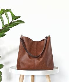 Minimalist and classic hobo bag in cognac brown *The exterior of the bag is made of high quality artificial leather in beautiful rich cognac brown color.  Very practical for carrying on the shoulder, and as a cross body (if crossbody strap is added).  The bag is light and well structured and the wider strap guarantees comfort for the shoulder.  *The interior is made of cotton fabric in medium grey.  It has 2 slip inner pockets which are perfect for your phone and smaller items.  *Magnetic snap c Versatile Cognac Hobo Bag For Everyday Use, Versatile Cognac Hobo Bag, Minimalist Brown Hobo Bag For Everyday, Brown Hobo Shoulder Bag For On-the-go, Brown Hobo Bag For Everyday, Minimalist Brown Bucket Bag For Everyday Use, Minimalist Brown Hobo Bag For Travel, Minimalist Brown Bucket Bag For Everyday, Everyday Large Capacity Brown Hobo Bag