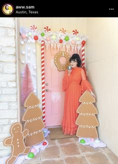 a woman standing in front of a door decorated with gingerbreads and christmas decorations