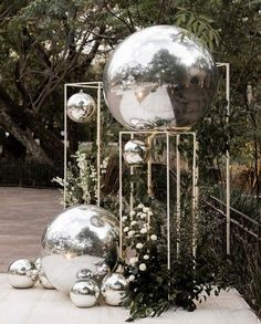 an outdoor display with metal balls and greenery