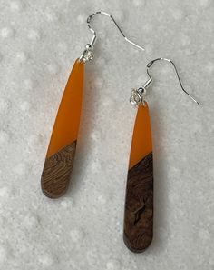 Tangerine Resin and miscellaneous woods in narrow drop dangles, all hanging from sterling silver wires and findings. Unique Orange Dangle Jewelry, Resin And Wood Earrings, Handmade Sterling Silver Orange Earrings, Artistic Orange Dangle Jewelry, Orange Resin Dangle Earrings, Nickel-free Orange Drop Earrings, Wood Earrings, Silver Wire, Sterling Silber