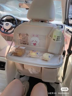 a baby seat in the back of a car with food and drinks on it's tray