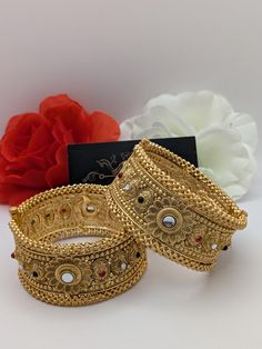 Indian bollywood fashion Kundan 2pcs openable bridal wedding gold plated bangles / kangan set These are high quality gold plated bangles set. Have done gold plating on it for a brilient shine. These looks great when you worn alone or in pair. They are sure to make your hands look beautiful. A popular combo to wear with many outfits. A perfect gift for your loved ones or yourself.  A perfect ornament for wedding, parties or any special event.  Stone Colour: Emerald, Ruby Pink, Clear 1 Bangles Surface Width: 3.4 cm Product colour may slightly vary due photographic lighting sources or your monitor settings.  Bangles sizes 2.25 inches = size 2.4  2.375 inches = size 2.6  2.5 inches = size  2.8 2.625 inches = size 2.10 Bohemian Heavy Bangle For Wedding, Heavy Bohemian Bangle For Wedding, Bollywood Style Bracelets With Intricate Design For Party, Bollywood Chandbali Wedding Bracelets, Bollywood Style Chandbali Bracelets For Wedding, Bohemian Stone Work Bracelets For Wedding, Bollywood Style Chandbali Wedding Bracelets, Bollywood Tilla Bracelets For Wedding, Bollywood Style Wedding Bracelets With Tilla