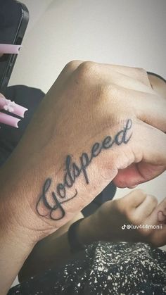 someone is writing on their wrist with the word godpeed written in cursive ink