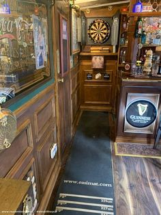 the inside of a bar with darts and other items on display behind glass doors that lead into another room