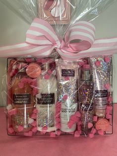 a pink gift box filled with bath products and confetti on top of a table