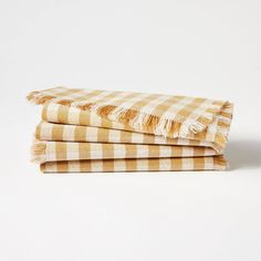 three yellow and white checkered towels stacked on top of each other