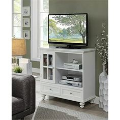 a flat screen tv sitting on top of a white entertainment center in a living room