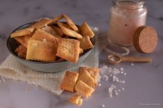 a bowl filled with crackers next to a glass of milk