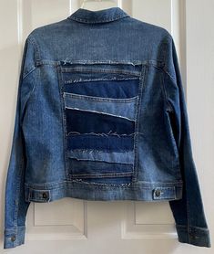 a blue jean jacket hanging on a white door