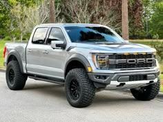 a silver truck is parked on the street