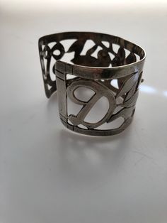 I purchased this handmade sterling silver cuff bracelet out of an estate of a seamstress back in my hometown about 25 years ago. The seamstress was active in the 1940s,1950s and 1960s. I had no idea she also dabbled in making sterling jewelry but I bought this and about 20 other pieces from her two sisters after she had passed away. The bracelet features a lovely openwork cut out design of a flower in the center flanked by two lovebirds and her initials D T ...one on each end. I am sure this is Vintage Sterling Silver Cuff Bracelet For Anniversary, Unique Cuff Bracelet For Anniversary, Unique Bangle Cuff Bracelet For Anniversary, Unique Anniversary Bangle Cuff Bracelet, Vintage Stamped 925 Cuff Bracelet For Wedding, Unique Engraved Cuff Bracelet For Anniversary, Vintage Sterling Silver Cuff Bangle, Vintage Sterling Silver Cuff Bracelet Gift, Unique Anniversary Bangle