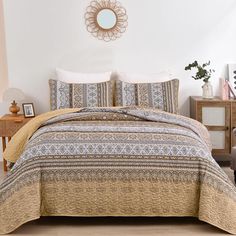 a bedroom with a bed covered in a beige and blue comforter