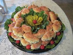 a platter filled with croissants and vegetables on top of a table