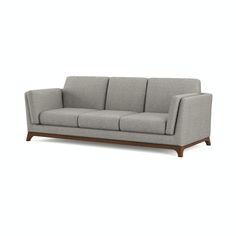 a gray couch with wooden legs on a white background