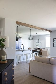 a living room filled with furniture and a large mirror on the wall above it's doorway