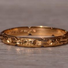 a close up of a gold ring on a wooden surface