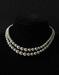 This is an exquisite vintage Monet double-stranded silver beaded choker necklace. The elegant piece features a Monet signed tag. With an adjustable length ranging from 15 to 17 inches, it is in excellent vintage condition. I do not routinely pack in gift boxes to prevent excess waste. Your item will be in a clear plastic baggie and securely padded for transport.   I am not a professional jewelry expert, and the information provided in this listing is based on my best knowledge and research. The vintage piece(s) you are considering is being sold as-is, and I encourage you to carefully review the detailed photos provided in the listing.  Important Points to Note:  Condition: The item is sold in its current condition, and any imperfections or wear are accurately represented in the listing pho Classic Silver Multi-strand Necklace, Classic Silver Double Strand Necklace, Elegant Silver Multi-strand Beaded Necklaces, Silver Single Strand Necklace For Evening, Adjustable Silver Choker Pearl Necklace, Elegant Multi-strand Silver Choker, Vintage Silver Choker For Evening, Adjustable Silver Pearl Choker Necklace, Silver Double Strand Necklaces For Evening