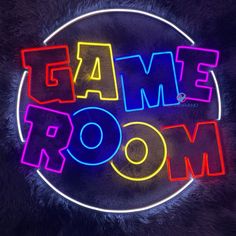 the word game room is lit up in neon colors on a black fur textured background