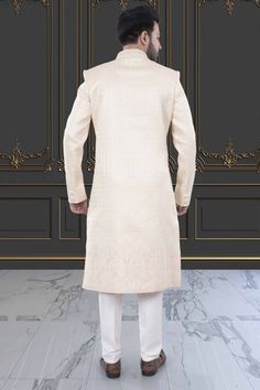 This men's sherwani (traditional Indian attire) features expertly crafted thread and sequin work. The intricate detailing adds a touch of elegance to any occasion. Made from high-quality materials, it offers both style and comfort. Perfect for those seeking a traditional yet sophisticated look. Cream Sherwani With Chikankari Embroidery And Long Sleeves, Cream Long Sleeve Sherwani With Chikankari Embroidery, Elegant Unstitched Sherwani With Straight Kurta, Unstitched Elegant Straight Kurta Sherwani, Traditional Long Sleeve Cream Sherwani, Traditional Cream Long Sleeve Sherwani, Elegant Cream Nehru Jacket For Designer Wear, Cream Long Sleeve Sherwani For Transitional Season, Elegant Off White Kurta For Ceremonial Occasions