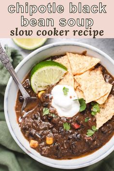 a white bowl filled with black bean soup and tortilla chips