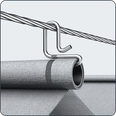 a close up of a piece of cloth with a metal hook attached to it and a roll of fabric next to it