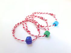 two red, white and blue bracelets on a white surface