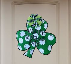 a st patrick's day door hanger with a green shamrock and polka dots