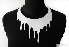 a mannequin with dripping white paint on it's neck and black shirt