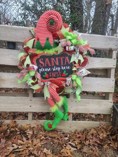 a christmas wreath sitting on top of a wooden bench