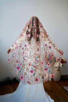 the veil is adorned with flowers and leaves