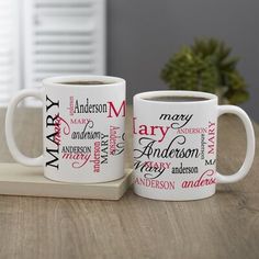 two coffee mugs sitting on top of a wooden table next to each other with names