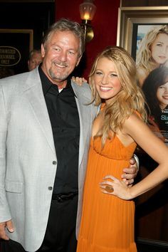 two people standing next to each other in front of a movie poster at an event