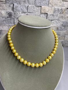 Gold Freshwater Pearl Necklace. This hand knotted strand features 47 Gold Freshwater Pearls AAA High Luster round 8.4-9.4 mm yellow overtones finished with a 8mm polished 14K Yellow Gold Filled bead clasp. This necklace measures 17 1/4 inches in length. I hand knotted this necklace with gold silk thread. These are genuine pearls, they are color enhanced, they are well matched with a few minor surface blemishes. The necklace pictured is the one you will receive, we hand craft our pieces one at a Yellow Round Pearl Necklace As A Gift, Yellow Round Pearl Necklace Gift, Yellow Pearl Necklace As A Gift, High Luster Yellow Gold Pearl Necklace With Round Beads, Elegant Yellow Round Bead Necklaces, Classic Yellow Necklaces For Formal Occasions, Elegant Yellow Jewelry With Round Beads, Classic Yellow Round Bead Jewelry, Formal Yellow Jewelry With Round Beads