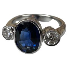 a blue and white diamond ring with three diamonds on the side, set in silver