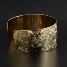 This cuff is hand-engraved and measures 1" wide by 6" long and was designed by First Nations artist Kelvin Thompson. This will fit a wrist between 6 1/4" and 6 1/2" in circumference. Custom lengths can be made on request. This piece is made to order and is titled 'Pod of Whales'.Whales usually signify longevity and strong community bonds due to their tendency to travel in close multi-family pods. In artworks, Orcas can be identified by a large, snub-nosed head; elongated nostrils; a wide, toothy Native American Totem, Native Jewelry, Large Animals, First Nations, Earrings Photo, Whales, Hand Engraving, Sterling Silver Charm, North West